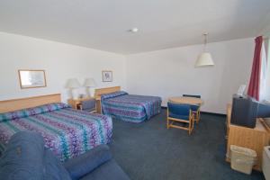 米苏拉布鲁克斯圣汽车旅馆的酒店客房配有床、沙发和桌子。