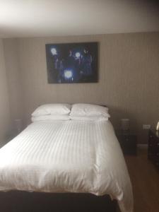 利物浦Liverpool Apartments的卧室配有白色的床,墙上配有电视