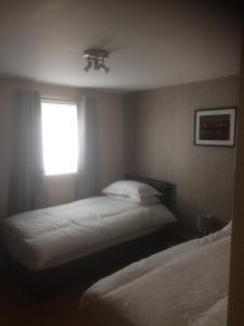 利物浦Liverpool Apartments的一间卧室设有两张床和窗户。