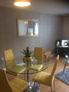 利物浦Liverpool Apartments的客厅配有玻璃桌和黄色椅子