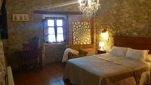 利亚内斯艾尔菊库度假屋的一间卧室设有一张床、一个窗户和一个吊灯。