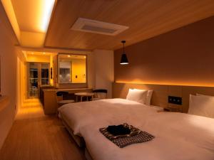 金泽金泽雨庵酒店的酒店客房设有两张床和一张桌子。