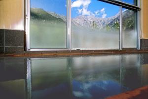 松本上高地西伊豆山日式旅馆的窗户前有水池的房间