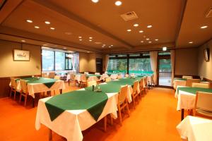 藏王温泉勒韦尔酒店的用餐室配有绿色的桌椅