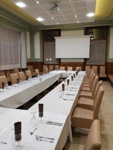 圣让德莫里耶讷欧洲酒店的一间会议室,配有桌椅和白色屏幕