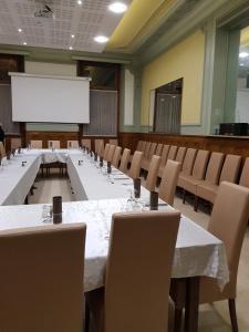 圣让德莫里耶讷欧洲酒店的一间会议室,配有桌椅和白色投影屏幕