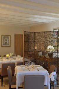 沙托鲁欧陆之家客栈的用餐室配有带白色桌布的桌子