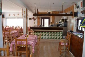 卡内·德·玛尔Hostal Casa Torrent的厨房以及带桌椅的用餐室。