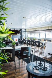 库奥皮奥Hotellilaiva Wuoksi的用餐室配有桌椅和植物