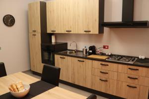 卡塞塔Vista Reale Apartment的厨房配有木制橱柜、水槽和桌子