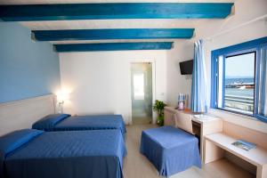 马劳萨日落海滩酒店的一间卧室设有两张蓝色的床和窗户