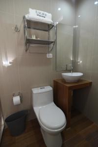 齐克拉约Hotel Escala的浴室配有白色卫生间和盥洗盆。