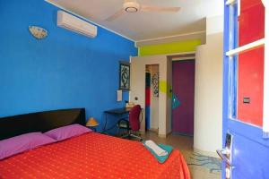 瓦加杜古Maison d'hôtes Chez Giuliana的一间卧室设有红色的床和蓝色的墙壁