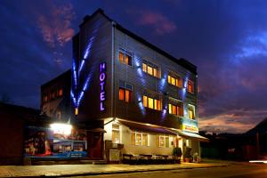 舒门梅赫德加莱尔酒店的建筑的侧面有 ⁇ 虹灯标志