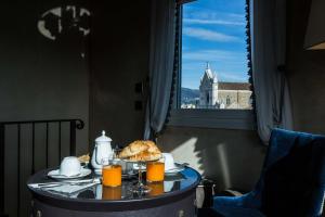 佛罗伦萨帕拉佐罗塞利切克尼酒店的一张桌子,上面放着一盘食物和橙汁