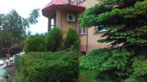塔尔诺布热格Noclegi-Zajazd"Mieszko"的前面有一堆灌木的房子