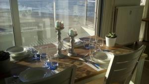 奥斯坦德Apartment Raversijde with Seaview的桌子上带板子和玻璃杯的桌子,带窗户