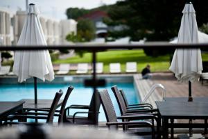 哥德堡哥德堡苹果酒店和会议中心的一组椅子和遮阳伞,位于游泳池旁