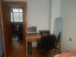 巴利亚多利德Apartamento Panaderos的一间卧室配有一张桌子、一台电脑和镜子