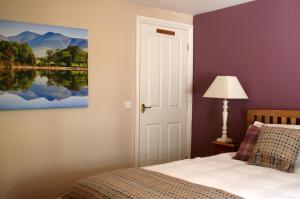 凯西克StoneyGill A的卧室配有一张床,墙上挂有绘画作品