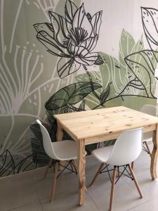 科尔多瓦Departamentos Duarte Quiros的一张木桌和椅子,配有花卉壁画