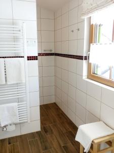 翁特拉梅尔高阿腾豪瑟旅馆的浴室设有白色瓷砖墙壁和淋浴。