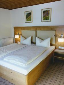 翁特拉梅尔高阿腾豪瑟旅馆的一间卧室配有一张带两个枕头的大木床