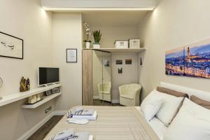 佛罗伦萨Little Suite Fortezza的白色的客房配有床和电视。