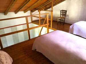 诺维利古雷橄榄园农庄酒店的一间卧室,卧室内配有一张床和一把椅子