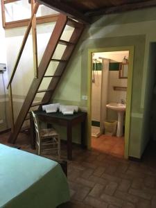 诺维利古雷橄榄园农庄酒店的阁楼间设有桌子和带水槽的浴室