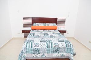 SabanetaGran Hotel Marien的一间卧室配有一张带蓝色和白色被子的床