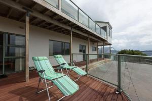 怀蒂昂格Ocean View B&B的两把绿色椅子坐在房子的阳台上