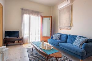 干尼亚Sody Magnificent Bay View的客厅配有蓝色的沙发和桌子