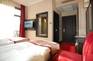 伊斯坦布尔苏丹穆罕默德酒店的酒店客房,配有床铺和红色椅子