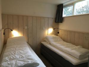 西泰尔斯海灵Bungalows Dellewal的墙上灯的房间里设有两张床