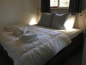 西泰尔斯海灵Bungalows Dellewal的白色的床、白色枕头和毛巾