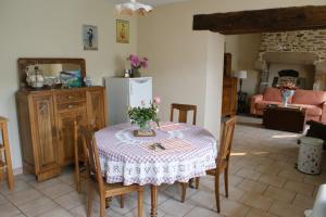 Saint-Denis-sur-SarthonChambre d'hôte Courtoux的厨房配有桌椅和冰箱