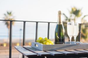 滨海比拉萨尔Vilasarmarlux II的一张桌子,上面放着一瓶香槟和葡萄