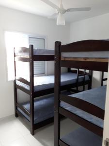 卡拉瓜塔图巴Residencial Martinica I的带吊扇的客房内的两张双层床