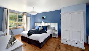 Vienne-en-Arthies维也纳阿提斯别墅住宿加早餐旅馆的一间蓝色卧室,配有一张床和电视