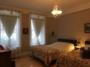 魁北克市切兹休伯特住宿加早餐酒店的一间卧室配有两张床和吊灯。