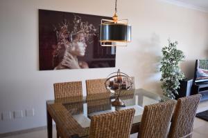 马贝拉La Concha Vista La Quinta的一间设有玻璃桌和椅子的用餐室