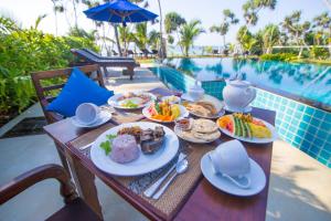 坦加拉兰卡海滩简易别墅酒店的桌边的餐桌,旁边放着盘子