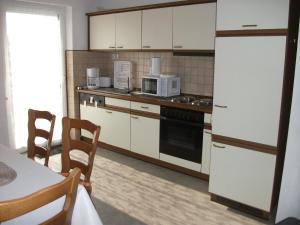 HambachFerienwohnung Fischer mit Balkon的厨房配有白色家电和桌椅