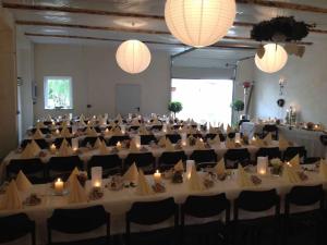 灿特Wirtshaus "Alte Post"的一个带白色桌椅的大型宴会厅