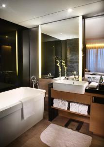 深圳深圳大梅沙京基海湾大酒店的一间带大浴缸和大镜子的浴室