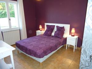 Châteauneuf-Val-Saint-Donatle petit coin de Noah的一间卧室配有一张紫色床、两张桌子和两盏灯。