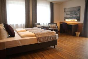 安达赫治贝肯勒内精品酒店的卧室配有一张床和一张桌子及椅子