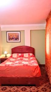 瓦拉斯Residencial Norandes的一间卧室配有一张红色的床和一张可拉式床罩