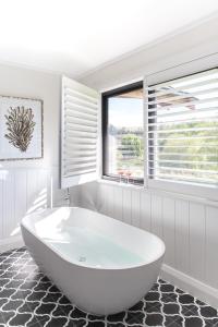 贝里马班都利度假村的带窗户的浴室内的白色浴缸